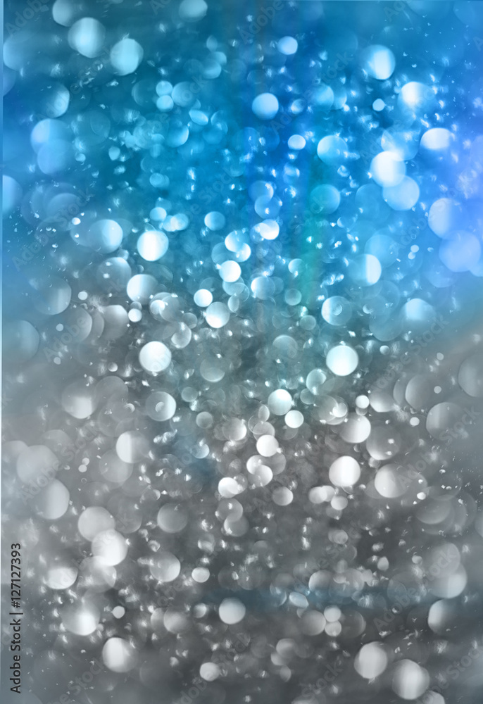 Abstract blurred blue background with rainy bokeh effect.