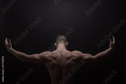 young man posing back muscles, rear view