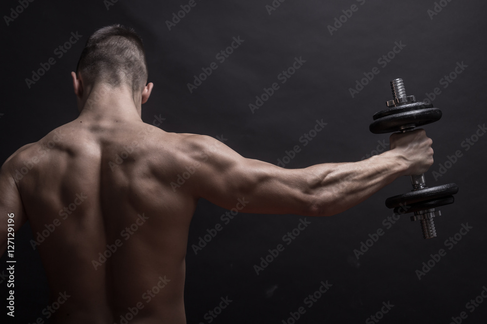 young man rear view, back arm extended dumbbell. Stock Photo | Adobe Stock
