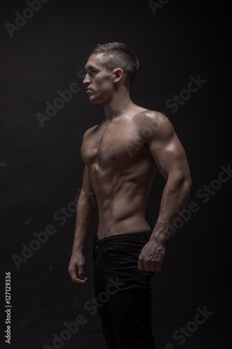 young man, bodybuilder posing, side view, profile