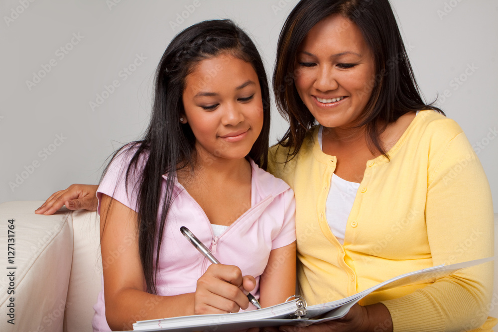 Mother helping her daughter with her homework. Mother helping her daughter with her homework.