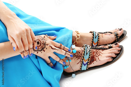 Female legs and hands with henna tattoo on white background
