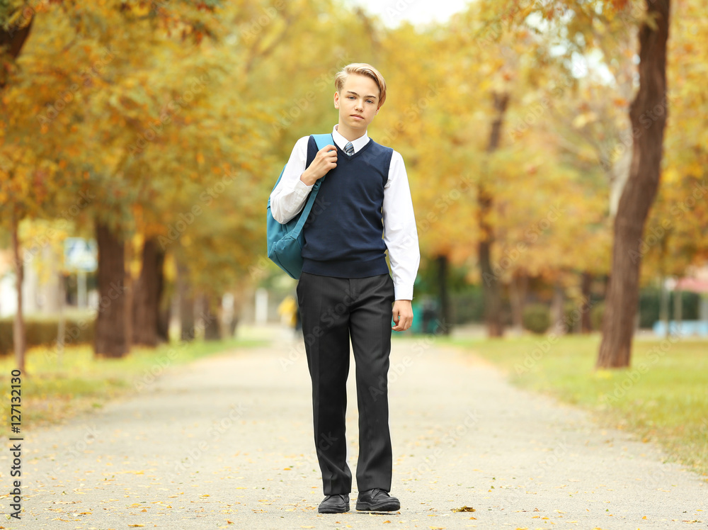 Cute teenager walking along pathway in park Cute teenager walking along pathway in park