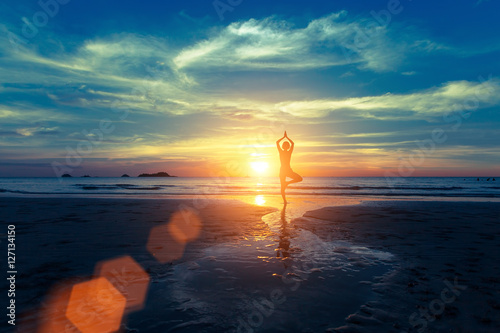 Yoga silhouette at sunset on the sea shore. Calm and self-control.