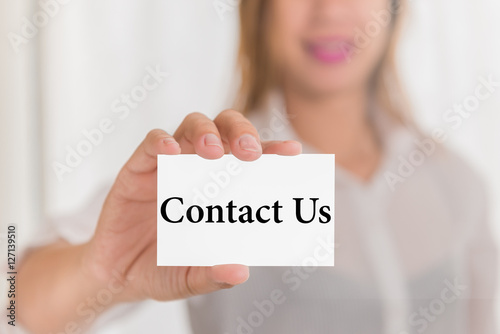 Contact us message word on card in hand of Friendly woman hand a