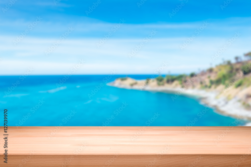 Wood table top on blurred blue sea background - can be used for