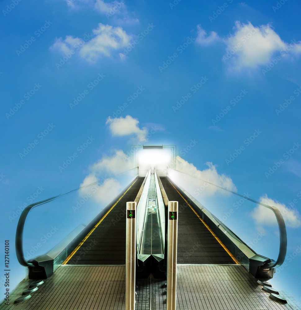Fototapeta premium Escalator walkway leading up to bright light with blue sky, concept of way to success or heaven