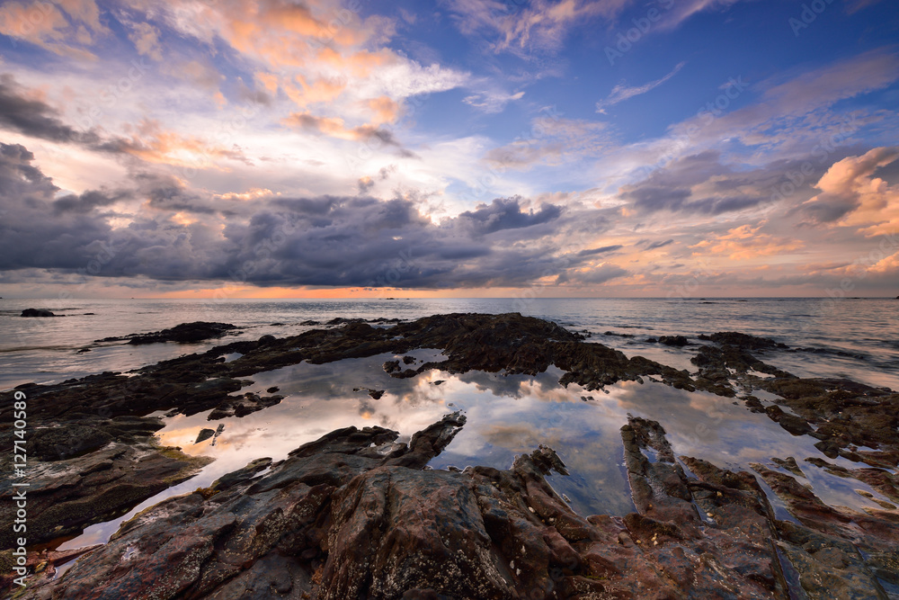 Fototapeta premium Cloud dramatic sunset and reflection on the water and rock at t