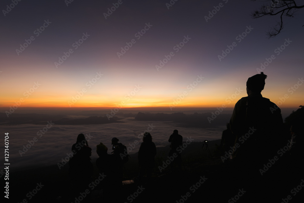 Silhouette of group of travellers enjoying a beautiful sunrise