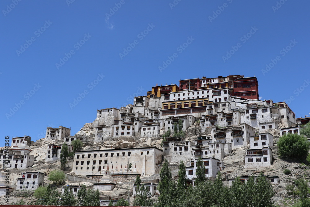 Naklejka premium Thiksay Tibetan Buddhist monastery is located on top of a hill in Thiksey village, near Leh in Ladakh, India. Visitors reguraly come to pray here.