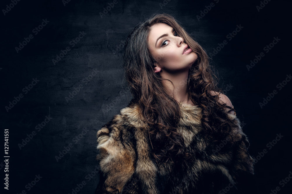 Brunette woman with long curly hair dressed in a fur coat. Brunette woman with long curly hair dressed in a fur coat.