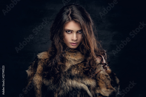 Brunette female dressed in a fur jacket.