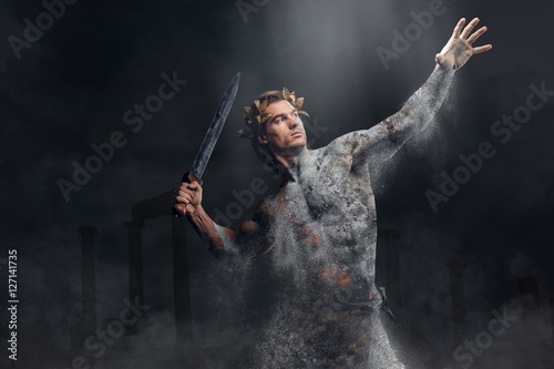 Crushing stone human athlete holds sword.
