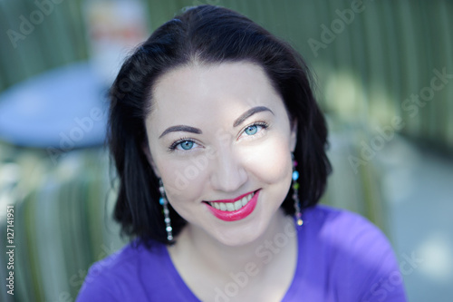 Portrait of young beautiful woman with dark hair and bright lipstick, close-up. © 060808