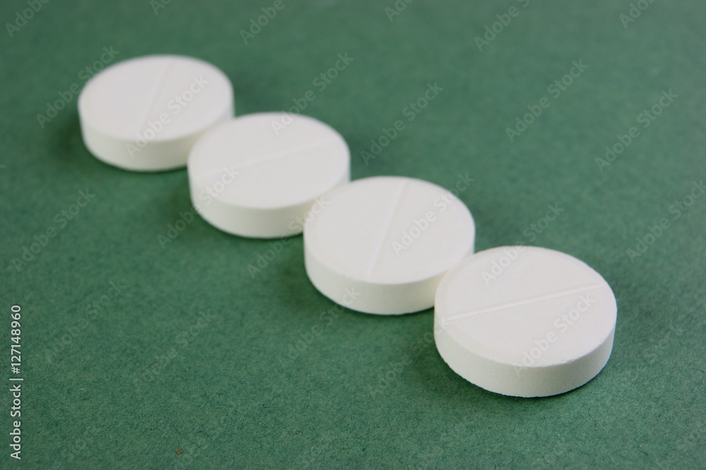 white tablets on a green background white tablets on a green background