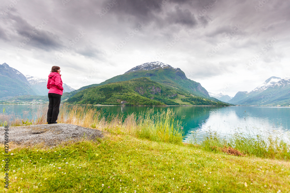 Woman tourist relaxing on fjord sea shore, Norway