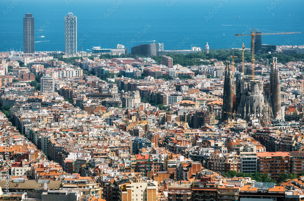 Aerial view of Barcelona, the Mediterranean sea, Sagrada Familia and The twin towers skyscrapers from Bunker El Carmel or Turo de la Rovira. Catalonia, Spain.