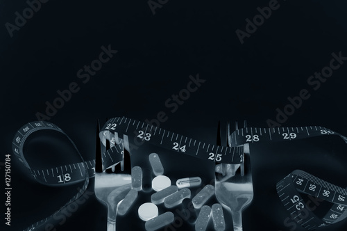 фотографія Invisible risk diet and healthy concept - Steel spoon a fork,pills and measuring