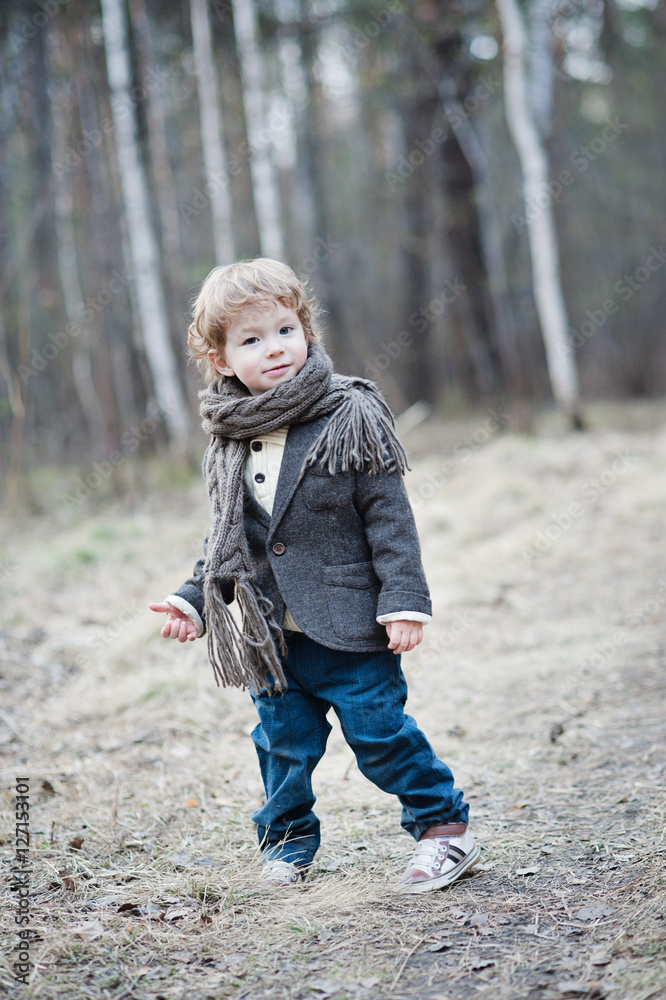 Full height portrait of a curly boy in the scarf. Full height portrait of a curly boy in the scarf.
