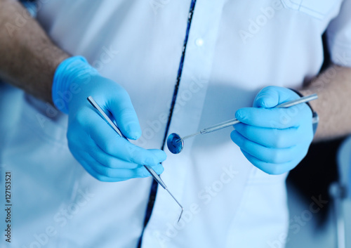 dental instruments in the hands of the doctor. Dentist in sterile latex gloves holding dental tools Close-up