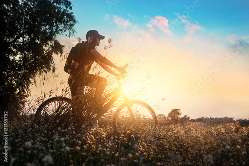 Biker on mountain bike adventure in beautiful flowers nature of rural