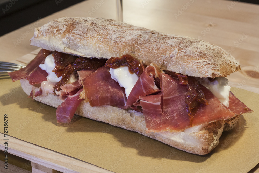 Foto Stock Panino prosciutto mozzarella, e pomodorini secchi Adobe Stock