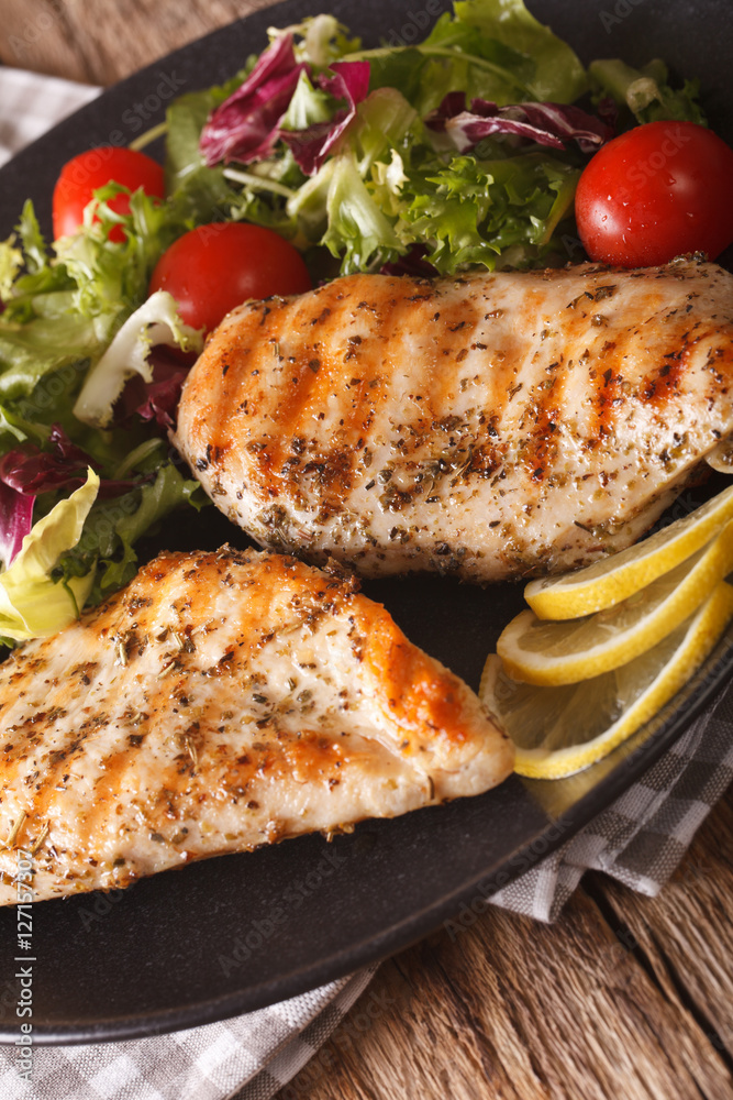 Grilled chicken breast with mixed salad close-up. Vertical Grilled chicken breast with mixed salad close-up. Vertical
