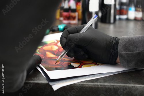 Salon tatuażu, artysta projektuje wzór.  photo
