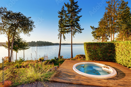 Fotografi Exterior of waterfront house with jacuzzi at the back yard..