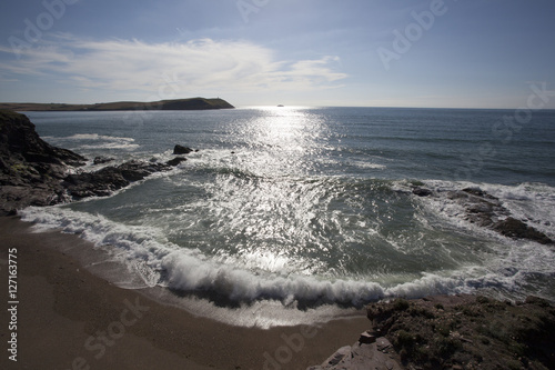 Waves roll in to a beach at Polzeath, Cornwall, UK