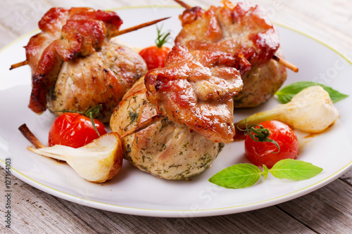 Meat rolls on scewers with cherry tomatoes and garlic photo