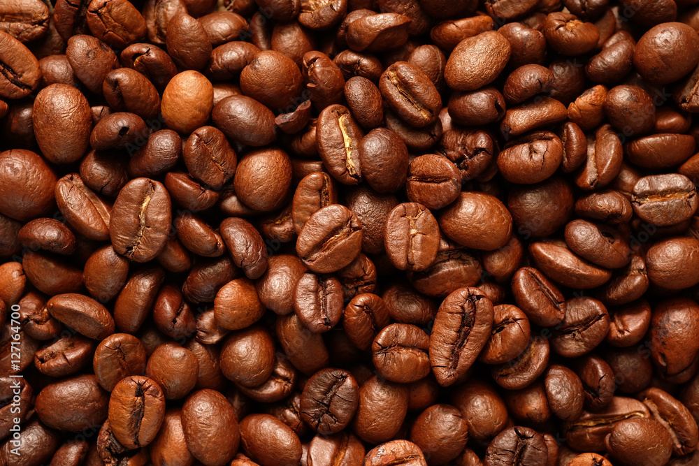 Roasted coffee beans close-up for use as a background texture. Roasted coffee beans close-up for use as a background texture.