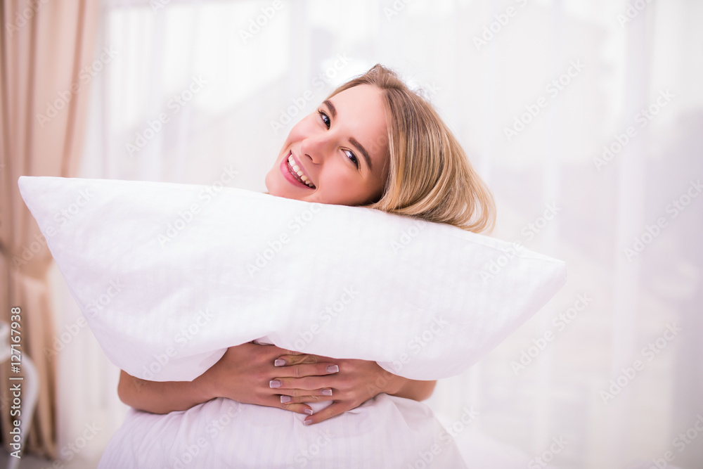 Happy white head woman holding pillow on the bed at home Stock 写真