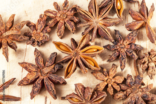 Stars of dried anise (Illicium verum) on wooden plank.