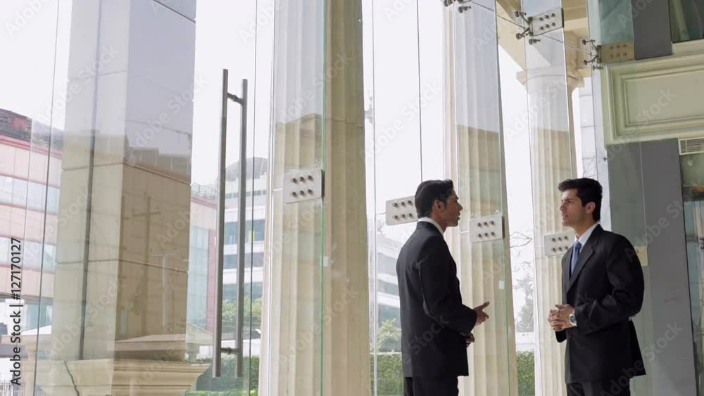 MS Businessmen talking in office lobby / Singapore MS Businessmen talking in office lobby / Singapore
