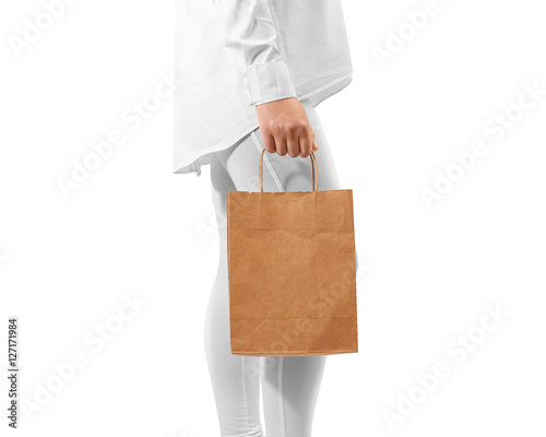Blank brown craft paper bag design mockup holding hand, clipping path. Woman hold kraft textured bundle mock up. Clear gift bagful branding template. Shopping carry package person arm. Handmade sac