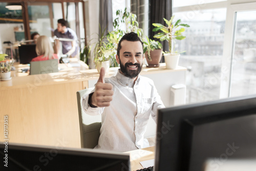 happy male office worker showing thumbs up