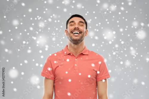 happy laughing man over snow background