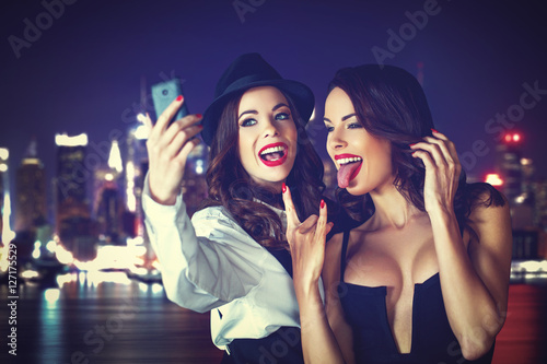 Young woman taking selfie in downtown at night