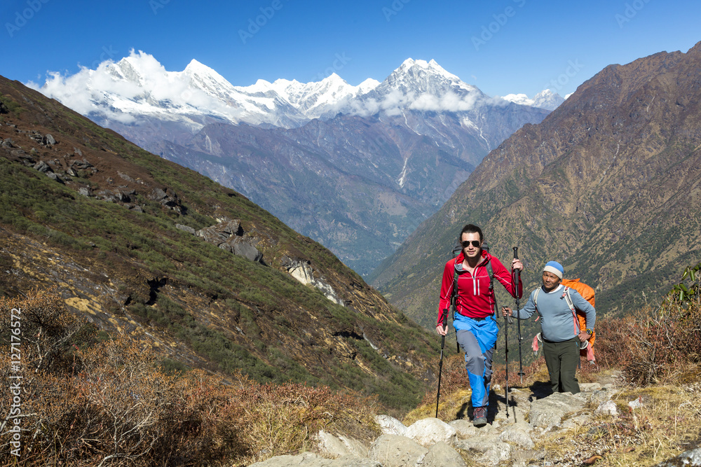 Young Hiker walking on Mountain Trail along with local Guide