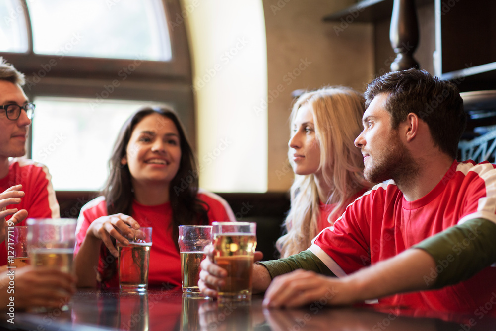 fans or friends watching football at sport bar