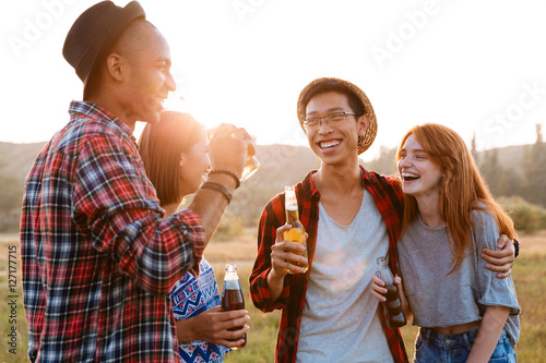 Two happy young couples drinking beer and soda together