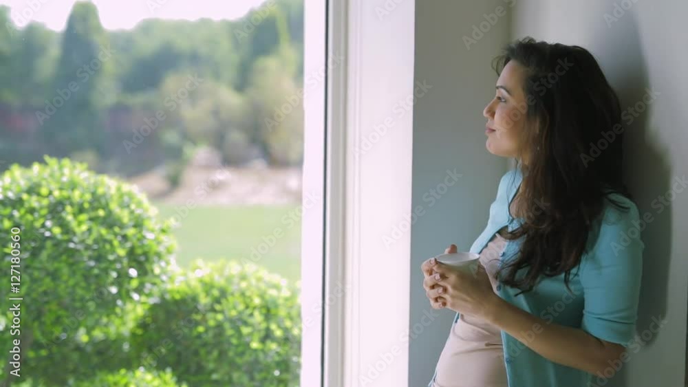 MS Woman standing at window drinking coffee / India MS Woman standing at window drinking coffee / India