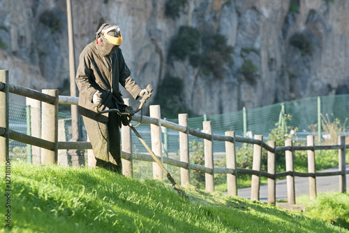 utility gardener with grass trimmer ,  lawn mower  lightweight , municipal services  worker photo