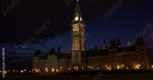 Ottawa, Ontario, Canada - illuminated Centre Block with Peace Tower at Parliament Hill at sunset with clouds - Timelapse with zoom in 