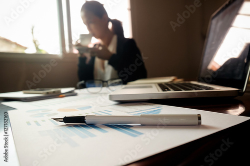 Business concept with copy space. Office desk table with pen focus and analysis chart, computer, notebook, cup of coffee on desk.Vintage tone Retro filter, selective focus...