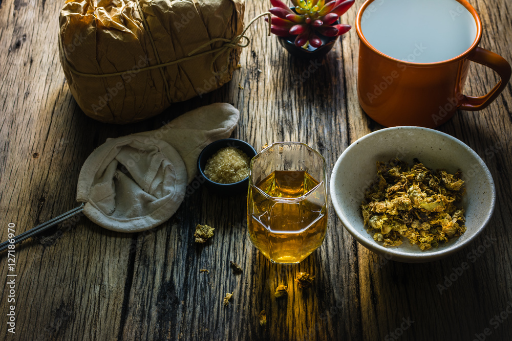 Focus Spot Chrysanthemum Tea and dried chrysanthemum on an old wooden table. Chrysanthemum blossoms are a type of herbal plants. In the morning, drink chrysanthemum Tea will make you feel refreshed. 