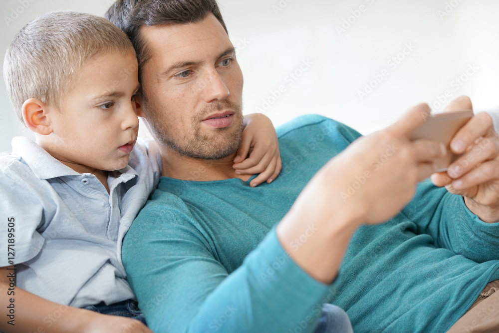 Daddy with son playing with smartphone Daddy with son playing with smartphone