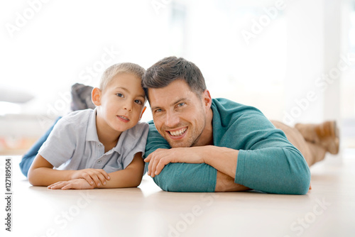 Portrait of daddy and son laying on floor