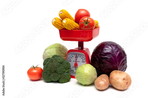 kitchen scales and fresh vegetables isolated on white background